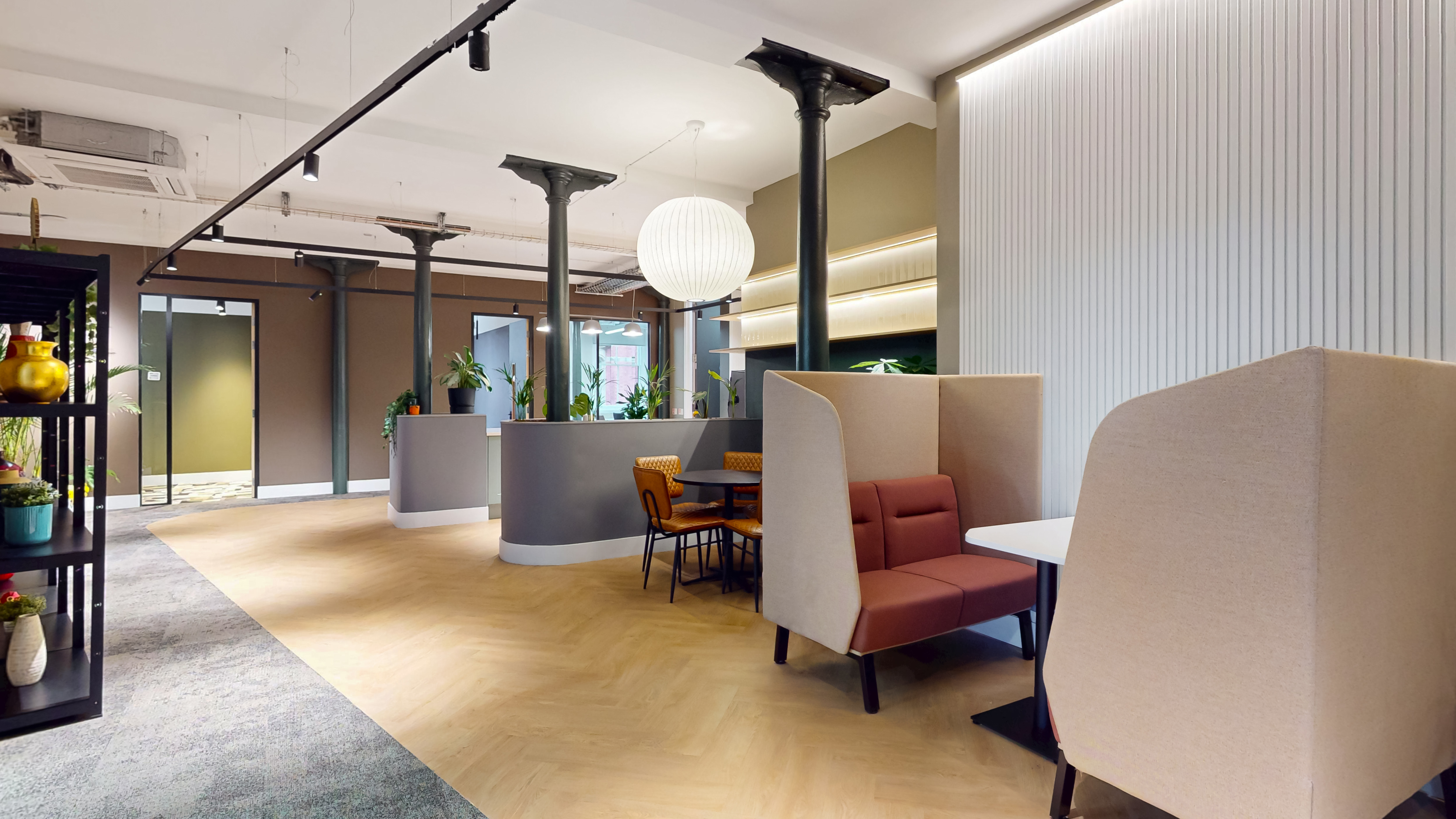 Boutique-club lounge with globe pendant lamps, leather seating pods and greenery