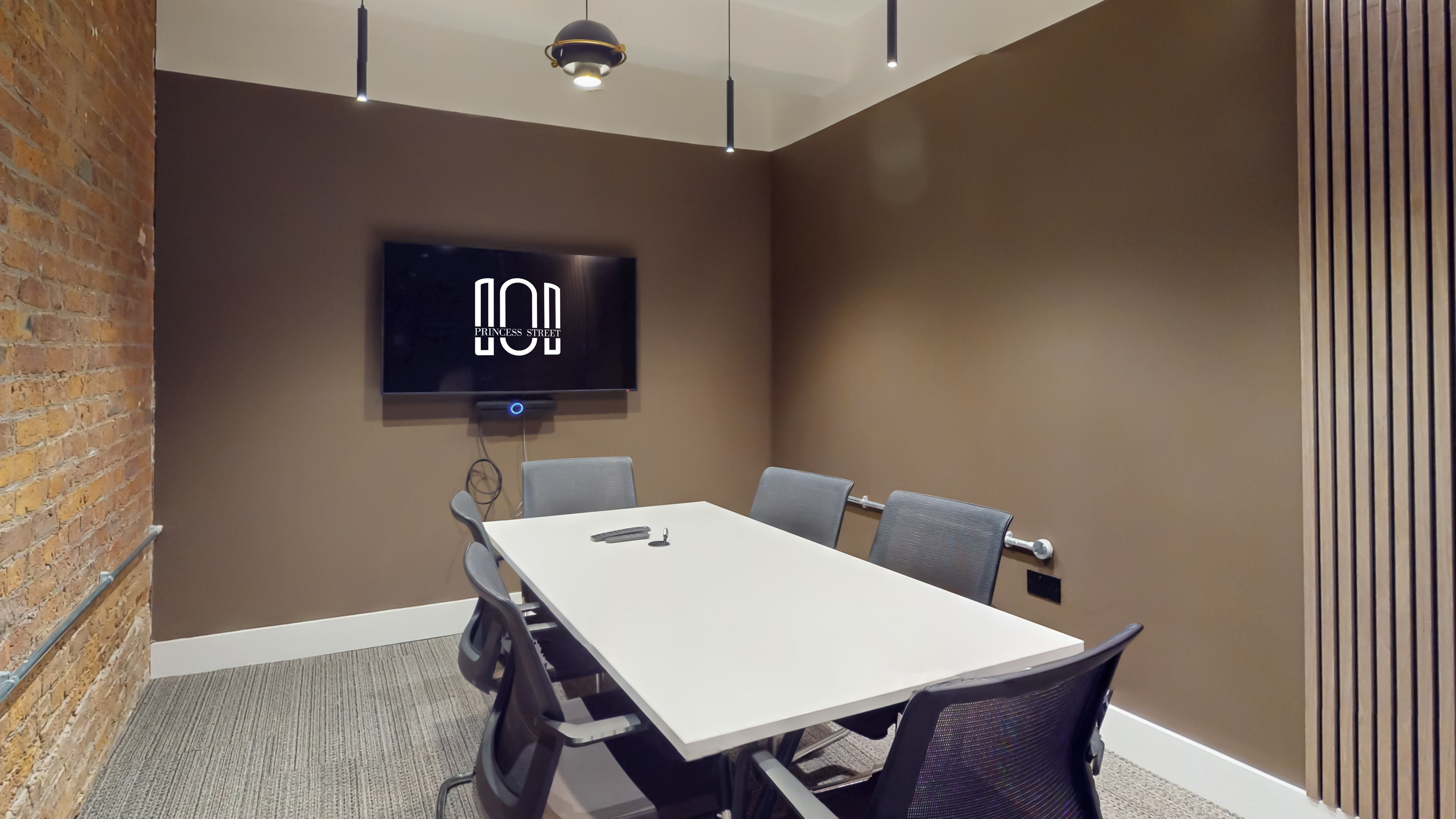 Private meeting room with exposed brick and screen